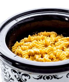 a crock pot filled with macaroni and cheese on top of a table