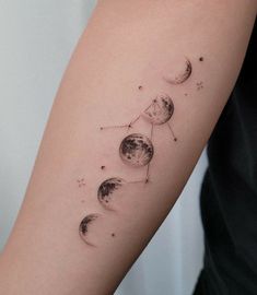 a woman's arm with three phases of the moon and stars on her left side