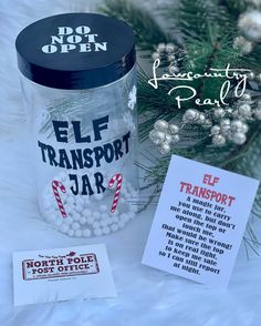 a glass jar filled with white balls next to a christmas tree and some paper tags