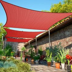 an outdoor area with potted plants and large red awning