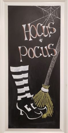 a chalkboard with the words hocps pocus written on it and a witch's boot