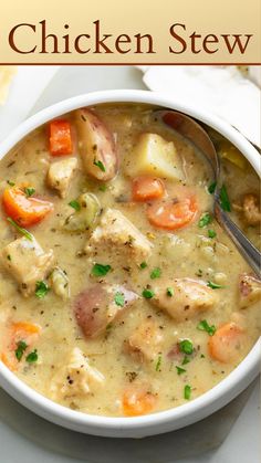 a white bowl filled with chicken stew on top of a table next to a spoon