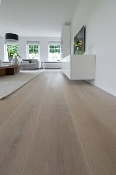 an empty living room with wood floors and white walls