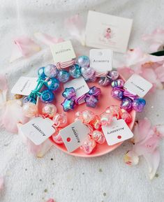 a pink plate topped with lots of different colored beads