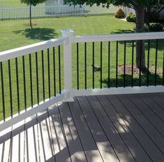 a white deck with black rails and a bird on the grass