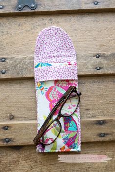 a pair of glasses sitting on top of a wooden table next to an eyeglass case