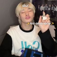 a person with blonde hair is holding a bottle in their hand and has the words skz written on it