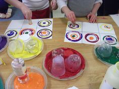 two children are sitting at a table making art