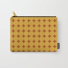 an orange and brown polka dot pattern carry - all pouch with gold zipper closures