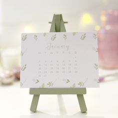 a desk calendar sitting on top of a wooden easel