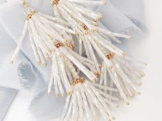 "NEW & WE ARE IN LOVE with these chic hand-beaded tassel wedding earrings, perfect for the boho bride at heart and a fun accessory to wear after the wedding too! Each piece is made in the USA. DETAILS *As shown, earrings feature soft white hand beaded tassels *The earrings measure about 4\" top to bottom and about 1\" wide *Finish is available in gold as shown The goal of your earrings is to compliment your dress and your overall wedding day look, not overpower it. We want our earrings to ma Gold Pearl Drop Tassel Earrings For Wedding, Glamorous Silver Tassel Earrings For Wedding, Glamorous Gold Tassel Earrings For Wedding, Party Bridal Earrings With Dangling Beads, Elegant Pearl Drop Tassel Earrings For Party, Elegant Pearl Drop Tassel Earrings For Wedding, Tassel Earrings For Wedding, Elegant Beaded Earrings With Dangling Beads For Festive Occasions, Gold Tassel Earrings For Wedding