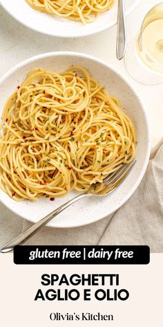 two bowls filled with spaghetti and sauce on top of a white table next to silverware