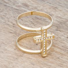 a gold ring with a cross on the middle and small white stones in the middle