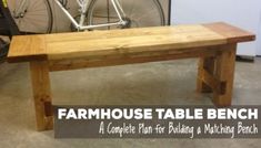 a wooden bench with the words farmhouse table bench on it's side in front of a bicycle rack