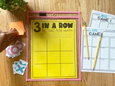 the 3 in a row activity mat is next to two pencils and some paper