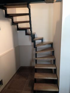 a set of stairs leading up to the top floor in a home with tile floors