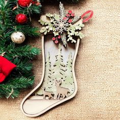 an ornament hanging from the side of a christmas tree with ornaments around it