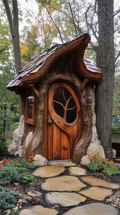 a tree stump house with a door and window in the middle of a garden area