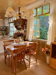 a dining room table and chairs in front of a window