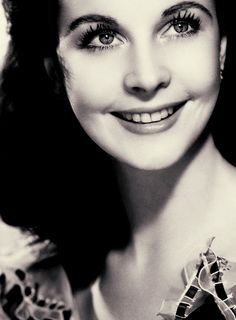 a black and white photo of a woman smiling