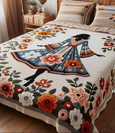 a bed covered in a blanket and pillows with an image of a woman on it