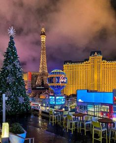 the christmas tree is lit up in front of the eiffel tower and casino