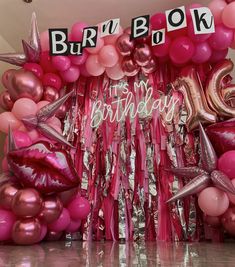 a bunch of balloons that are in front of a birthday sign and some letters on the wall