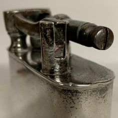 an old silver flask with a metal handle and nozzles on the top