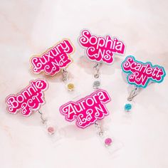 four name badge holders with swarong stones on each one and the word sorry to you in pink