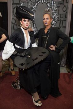 two women dressed in black and white posing for the camera