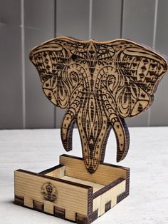 an elephant carved from wood sitting on top of a wooden box