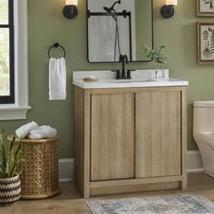 a bathroom with green walls and white fixtures