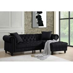 a black couch sitting in front of a window