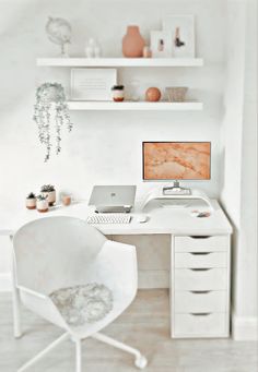 a white desk with a laptop computer on top of it and shelves above the desk