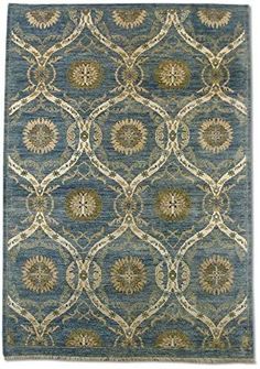 a blue and beige rug with an intricate design on the bottom, in front of a white background