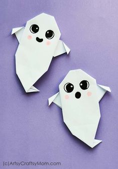 two origami bats with eyes and nose on purple paper, one is cut out to look like a ghost