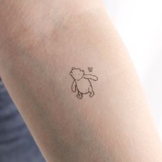 a person with a small tattoo on their arm that has a teddy bear drawn on it