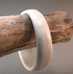 This small wave bracelet feature a smooth asymmetrical form. Hand shaped and finished this little bangle resembles a piece of ancient ivory but uses no animal products. Smaller size won't fall off smaller hands. Finished to a matte burnished texture.  7 1/8" (180 mm) inside circumference 2 3/8" (60 mm) inside diameter 3/4" (20 mm) wide .8 oz / 25 g To facilitate placement slip a plastic bag on over the hand to reduce friction when sliding This bracelet in place. These are waterproof so wetting the plastic will also reduce friction and will not harm the bracelet. Like this design but too big or too small?  Custom made variations of size and shape are available made-to-order, please make a request. Design is inspired by ancient designs and brought to life with modern materials, each of these Wave Bracelet, Animal Products, Ancient Designs, Hand Shapes, Small Hands, Bracelet Sizes, Bangle Bracelet, Plastic Bag, Arm Band