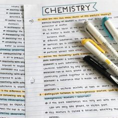 three pens sitting on top of an open notebook with the word chemistry written in cursive writing