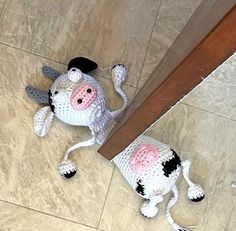 a stuffed cow laying on the floor next to a mirror