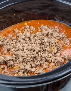 a crock pot filled with ground beef and tomato sauce