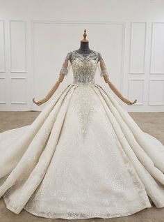 a wedding dress on display in a room with white walls and floor to ceiling windows