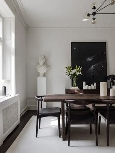 a dining room table with chairs and vases on it