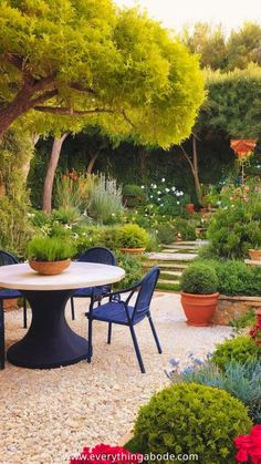 a table and chairs in the middle of a garden