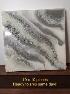 a white and gray painting sitting on top of a wooden table