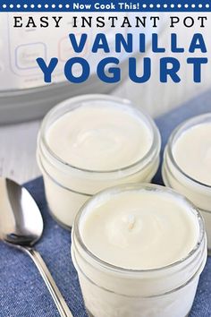 three jars filled with yogurt sitting on top of a blue cloth next to a spoon