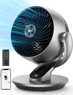 an electric fan sitting on top of a table next to a cell phone