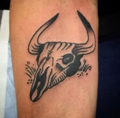 a black and white bull skull tattoo on the right arm with an arrow in it