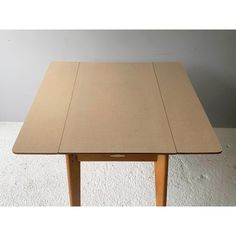 a wooden table sitting on top of a white carpeted floor next to a wall