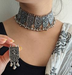 "Add charm and charisma to your beautiful personality with these stunningly handcrafted Afghani chokers. Earrings are also designed beautifully and compliment the choker very well. Wear it with any of your formal or casual outfits and grab compliments all the way! Length of the metal part in the choker is 8\" approx with an adjustable black chord (dori at the back) Weight of the choker is 75 gms (lightweight) Each earring weighs 12 gms Note: All in stock items will be shipped from New Delhi, Ind Black Metal Jewelry, Beautiful Personality, Indian Choker Necklace, Oxidised Silver Jewelry, Choker Necklace Designs, Antique Jewellery Designs, Antique Silver Jewelry, Fancy Jewellery Designs, Silver Jewellery Indian